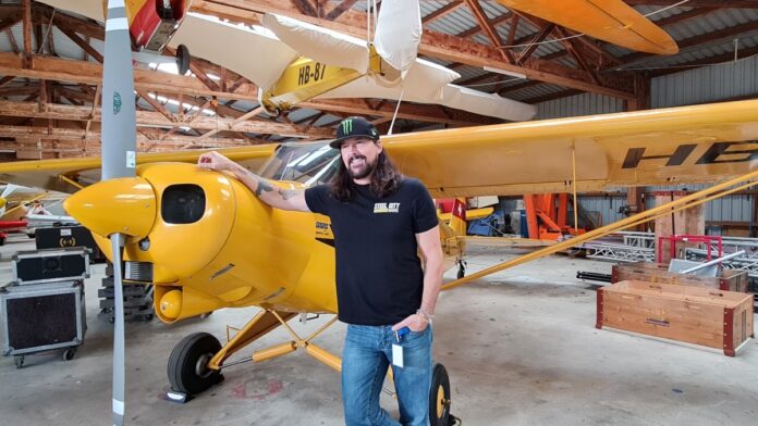 Rick Monroe with a yellow airplane at the back